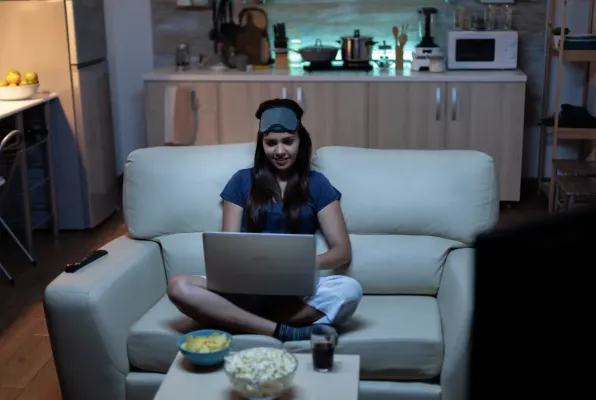 kvinna-sitter-i-en-soffa-med-en-laptop-i-knat