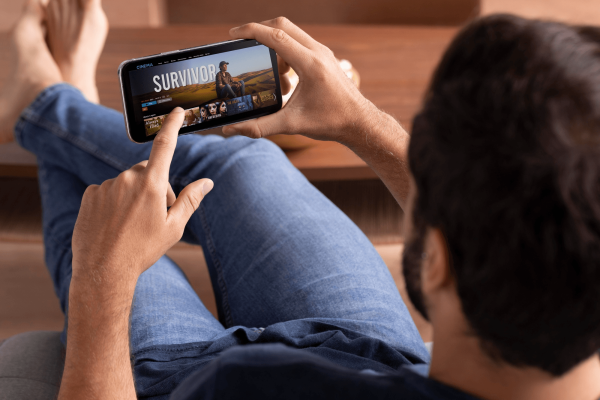man-streamar-filmer-och-serier-pa-mobil-i-soffan